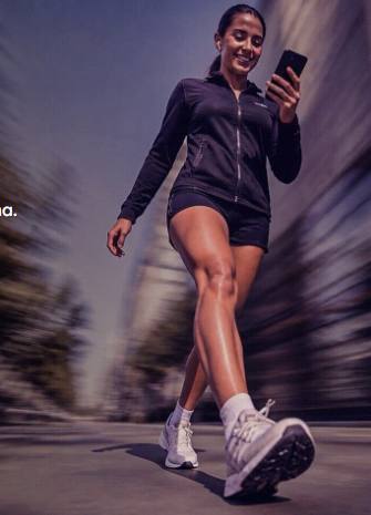 Runner caminando mientras revisa su smartphone